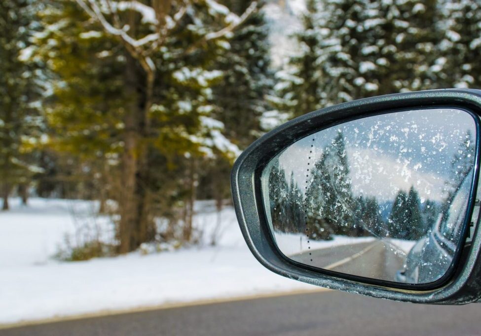 framed side mirror beside snow covered field